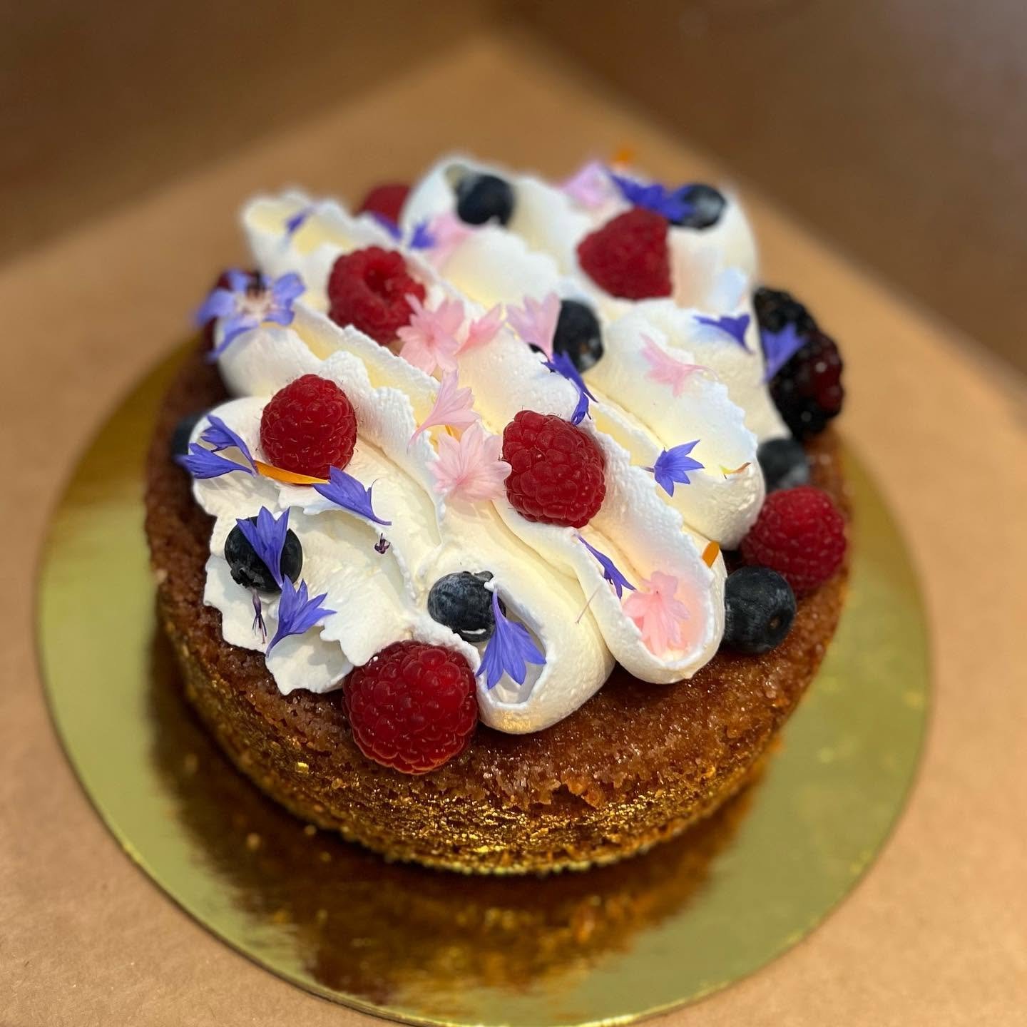 Berry cream cake with edible flowers